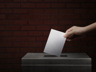 Hand holding ballot paper for election vote concept background.