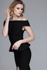 Young beautiful woman in black dress. Curly blond hair.