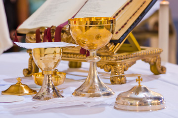 pisside and chalice contain wine and hosts on the altar of the mass