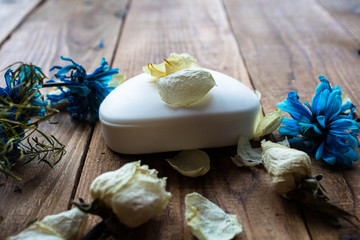 soap and white rose and violet on a wooden background