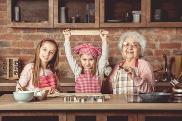 Little grandchilds ready to make cookies with grandmother