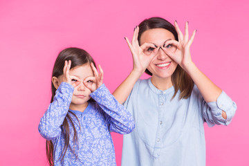 Holidays weekend leisure comfort gatherings birthday concept. Funny funky delightful cute daughter and mother making glasses with fingers fooling around