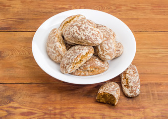 Gingerbreads on white dish and beside on a rustic table