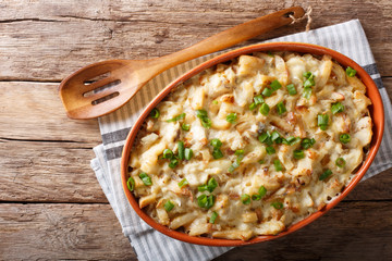 Portuguese food: casserole with cod, potatoes, onions and cream in a baking dish close-up....