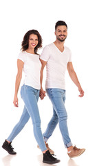 Fototapeta premium young happy casual couple is walking and holding hands