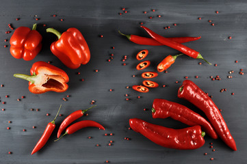 A set of a variety of red pepper. In the frame, pepper is cayenne, sweet and Ramiro sort. Dark wooden background. Close-up. View from above.