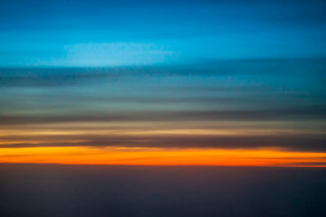 Naklejka na ściany i meble Dark sky blue and red from the window of the plane in the early morning at sunrise, landscape