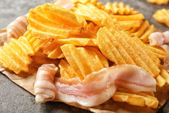 Crispy potato chips with bacon on table, closeup