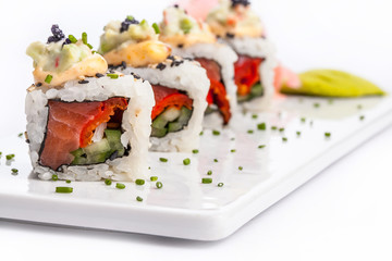 Sushi rolls on a white plate with white background.