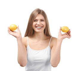 Beautiful young woman with ripe lemons on white background