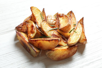 Tasty potato wedges on wooden table