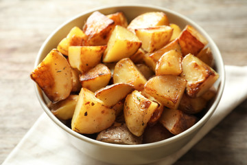 Tasty potato wedges in bowl, closeup