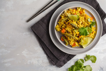 Vegetarian curry rice with vegetables in a gray plate. Top view, copy space. Healthy vegan food concept, detox, vegetable diet.