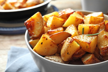 Tasty potato wedges in bowl, closeup