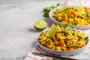 Vegetarian curry rice with vegetables and coconut cream in gray plates. Copy space, food background. Healthy vegan food concept, detox, vegetable diet.