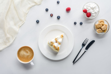 top view of delicious piece of cake with berries and coffee on white table
