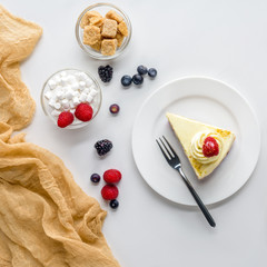 top view of piece of delicious cake with berries on white table