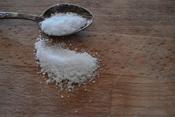 Sea salt crystals whit spoon at rustic wooden background 