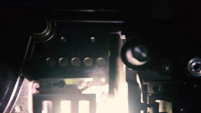 Movie projector super 8mm running tracking shot machinery detail on spool sprocket and film strip