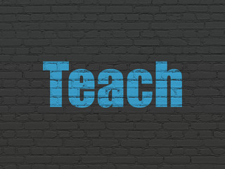 Education concept: Painted blue text Teach on Black Brick wall background