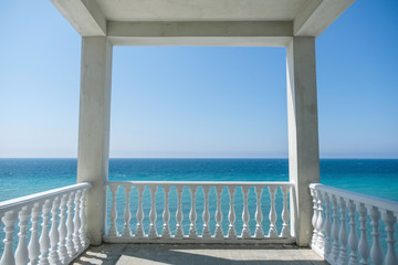 Fototapeta na wymiar White gazebo on the waterfront with seascape view. Close up view