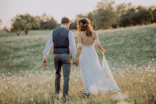 Beautiful bride and groom at sunset in green nature.