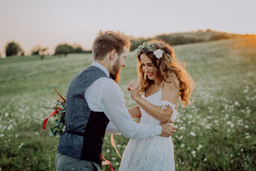 Beautiful bride and groom at sunset in green nature.