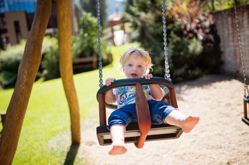 Little boy on the swing at the playground.