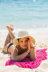 Beautiful woman in straw hat on the beach