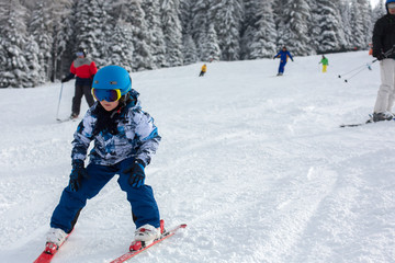 Fototapeta na wymiar Cute preschool child, skiing in Austrian winter resort on a clear day