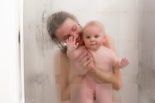 Mother and baby boy in shower, drops of water