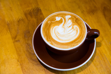 Late hot offee with late art in cup on wood table