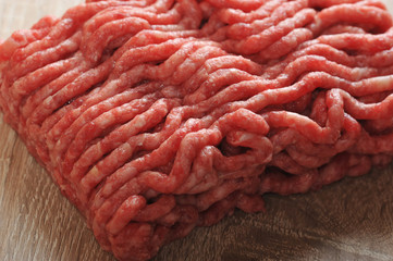 Minced meat for making steaks, cutlets. Light wooden background. View from above. Close-up. Macro photography.