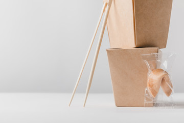 noodles boxes with chopsticks and chinese fortune cookie on table