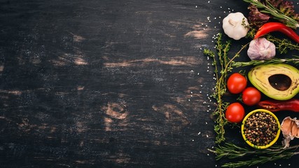 The background of cooking. A set of spices and fresh vegetables. Top view. Free space for your text. On a wooden background.