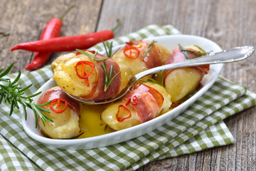 Pikante Käse-Drillinge mit Südtiroler Bauernspeck, Rosmarin und Chilischeiben in Olivenöl gebacken – Hot cheese stuffed rosemary potatoes wrapped in South Tyrolean bacon, baked in olive oil with chili