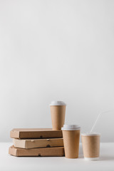 pizza boxes and coffee in paper cups on table