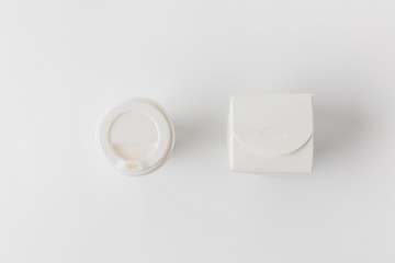 top view of disposable coffee cup and noodles box on white surface