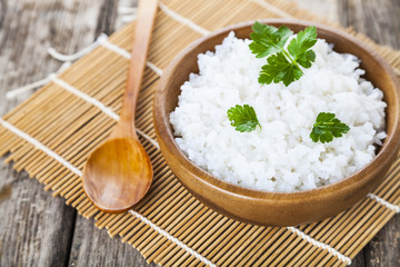 Boiled rice in a wooden bowl and spoon