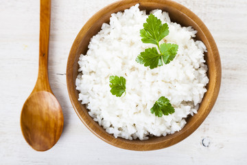 Fototapeta na wymiar Boiled rice in a wooden bowl and spoon