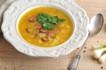 Pea soup with smoked meats and fresh parsley. Pea soup with smoked meats and fresh parsley. Next to the plate is a spoon, green onions. Close-up.