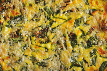 Open pie of quiche with spinach and green onions. Puff filling. Close-up.