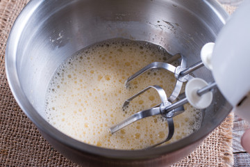 Cooking, whipping eggs with electric whisk in bowl