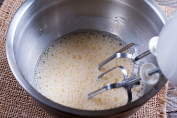 Cooking, whipping eggs with electric whisk in bowl