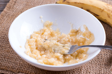 Slices of banana in a bowl and fork