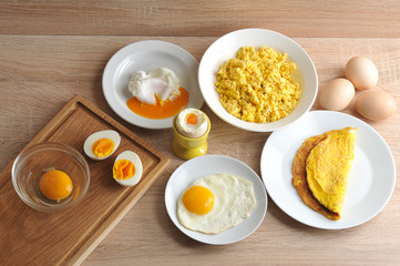 Various ways of cooking chicken eggs. Omelette, poached, soft-boiled, hard-boiled, fried, scrambled eggs.   Close-up.