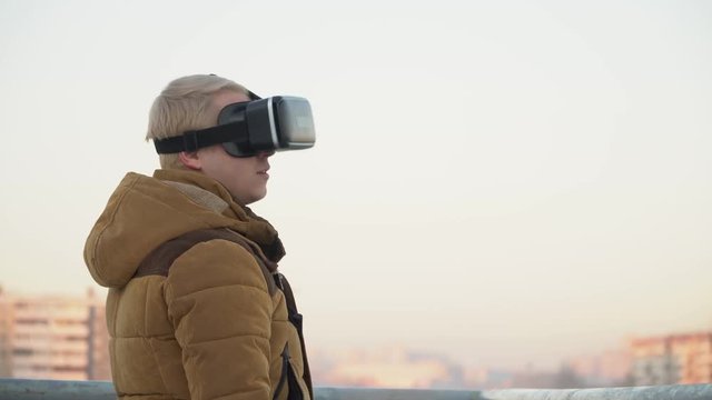 man dresses virtual reality glasses on the street in the background of the city
