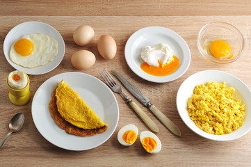 Various ways of cooking chicken eggs. Omelette, poached, soft-boiled, hard-boiled, fried, scrambled eggs.  Top view. Close-up.