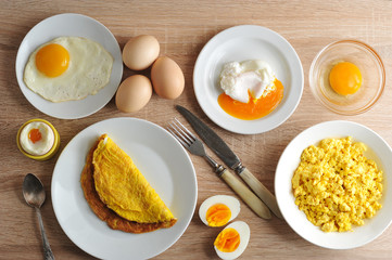 Various ways of cooking chicken eggs. Omelette, poached, soft-boiled, hard-boiled, fried, scrambled eggs.  Top view. Close-up.