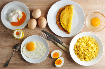Various ways of cooking chicken eggs. Omelette, poached, soft-boiled, hard-boiled, fried, scrambled eggs.  Top view. Close-up.